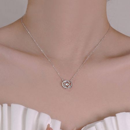 Detailed view of the double C pendant on the sterling silver necklace.
