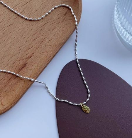Collar de cadena de cuentas con colgante de oro de plata esterlina 925 - Primer plano de un collar de cadena de cuentas de plata esterlina 925 con un colgante de oro grabado con las palabras 'SE' y 'AMOR'.