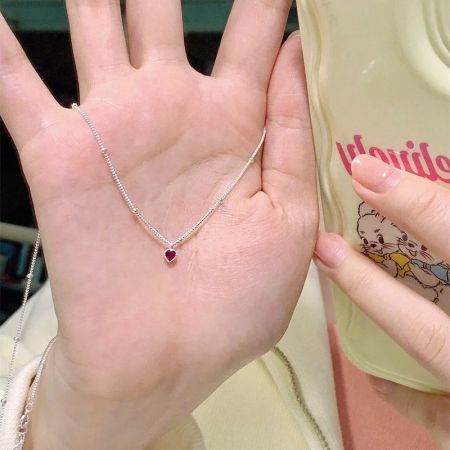 Another view of the sterling silver necklace with a heart-shaped red gemstone pendant.