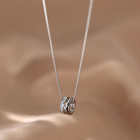 Detailed view of the silver choker with an interlocking circle pendant, one circle adorned with sparkling zircons.