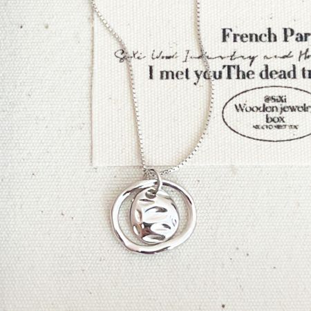 Collier en argent sterling avec un pendentif en cercles entrelacés, mettant en valeur son design unique.