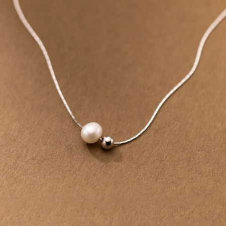 Collar de Cadena de Serpiente de Perla de Plata Esterlina 925 - Una toma de producto en primer plano de un collar de cadena de serpiente de plata esterlina 925 con una sola perla blanca elegante y una pequeña cuenta de plata.