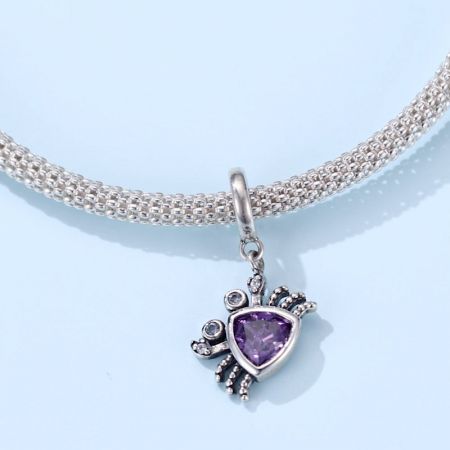 De paarse krab charme hanger elegant weergegeven aan een zilveren ketting.
