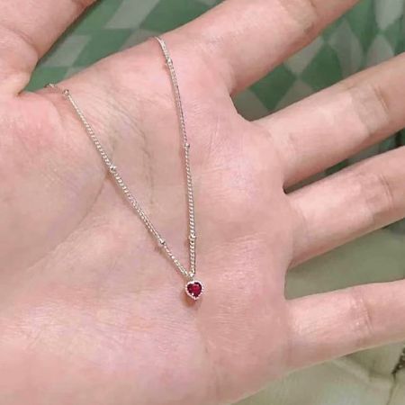 Collares de cadena con pequeñas cuentas de zirconia en forma de corazón de plata esterlina 925 - Un primer plano de un collar de plata esterlina 925 con un delicado colgante de zirconia roja en forma de corazón, mostrando su fina cadena y brillante destello.