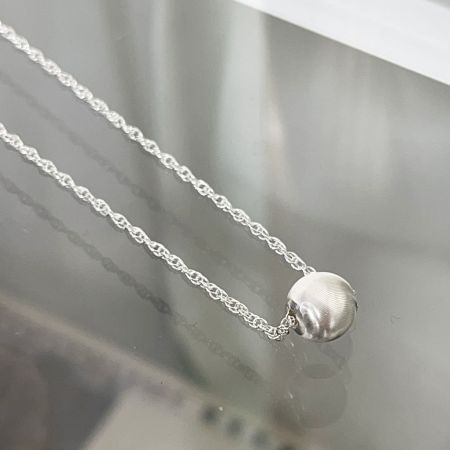 Vista detallada del colgante esférico de plata esterlina de 8 mm en el collar tipo choker.