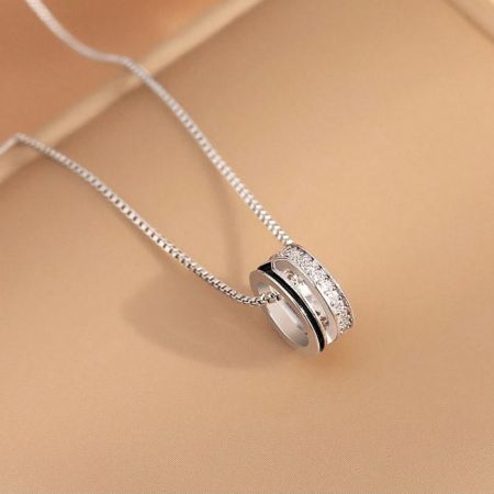 A minimalist silver necklace from the set with a single sparkling stone pendant.