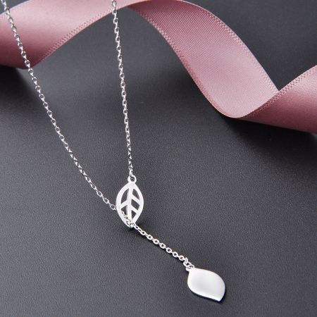 Vista detallada del collar con borlas de hoja de plata esterlina que muestra su exclusivo diseño de colgante de dos partes.