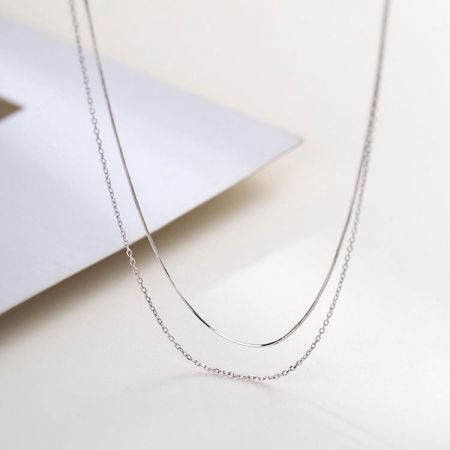 Collar de Cadena de Serpiente y Eslabones de Doble Capa de Plata 925 - Un conjunto de collares de plata esterlina 925 de doble capa, que presenta una elegante cadena de serpiente y una clásica cadena de eslabones, exhibido sobre un fondo blanco.