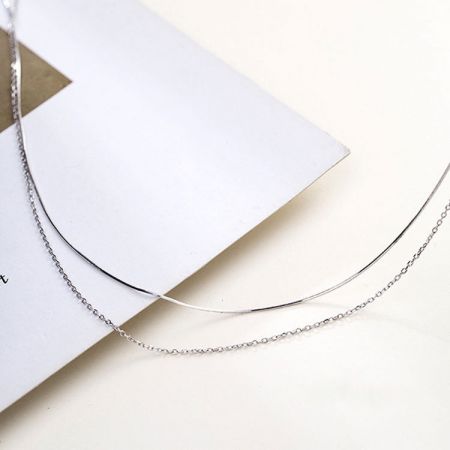 Scatto ravvicinato del prodotto del set di collane a doppio strato in argento sterling su uno sfondo neutro.