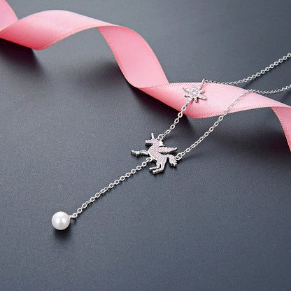 Close-up of two silver necklaces showcasing intricate charm details and a lustrous pearl.