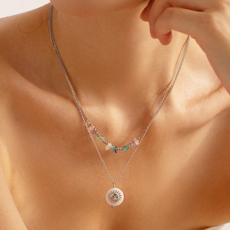 Modell trägt die geschichteten Halsketten im Strandstil aus rostfreiem Stahl mit Sonnenanhänger.
