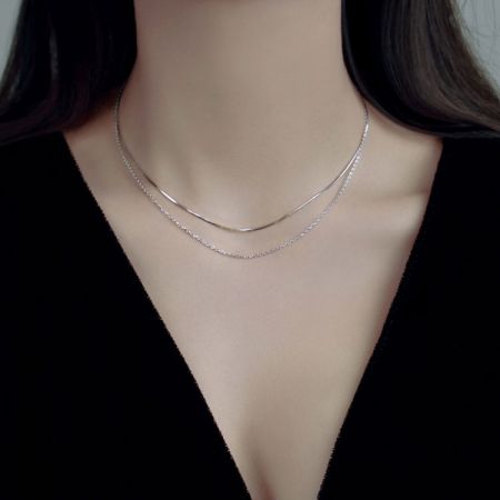 Una donna che indossa il set di collane a catena a doppio strato in argento 925 per mostrare la sua vestibilità.