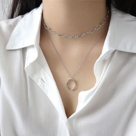 La version en argent sterling 925 du collier pendentif ovale irrégulier porté par un modèle, mettant en avant sa polyvalence.