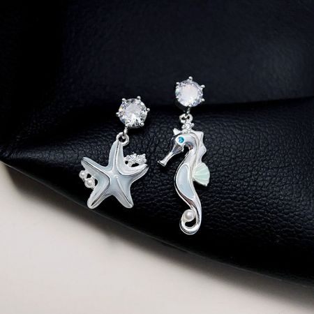 Un'altra prospettiva degli orecchini a tema oceanico, che mostrano le delicate perle e i chiodini di cristallo.
