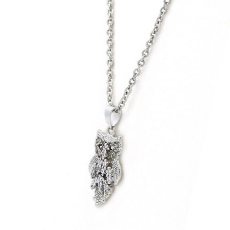 Close-up van de zilveren uil hanger ketting, met nadruk op de textuurdetails en versieringen.