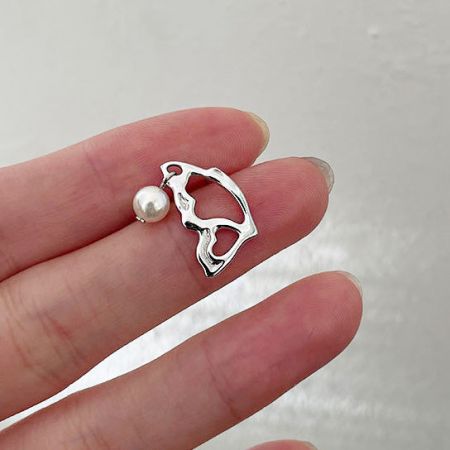 Un elegante orecchino a perno con perla e una goccia d'argento astratta, parte della collezione versatile.
