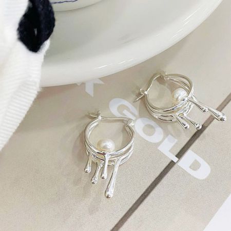 Orecchini a cerchio liquido con goccia di perla in argento sterling 925 - Scatto di prodotto in studio degli orecchini a cerchio liquido con goccia di perla in argento sterling 925, che mostrano il loro design unico e fluido e l'accento centrale della perla su uno sfondo pulito.