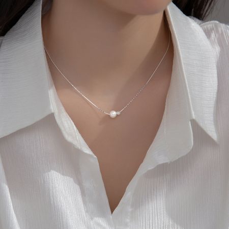 A model wearing the sterling silver pearl snake chain necklace, showcasing its length and style.