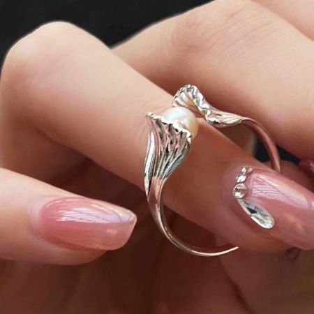 Anillo de plata elegante con una sola perla, que muestra el diseño minimalista dentro del conjunto de estilo francés.