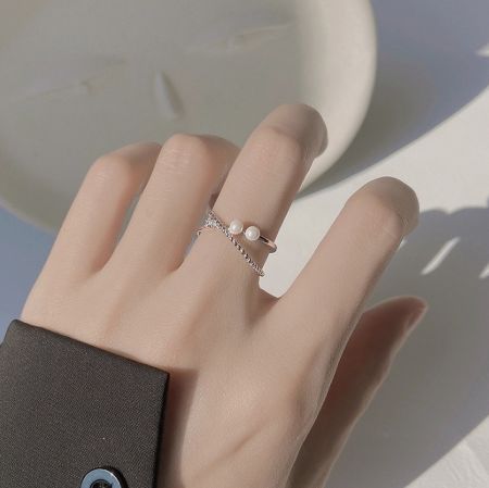 El anillo cruzado de perla de plata esterlina 925 llevado en la mano de un maniquí para mostrar su ajuste y estilo.