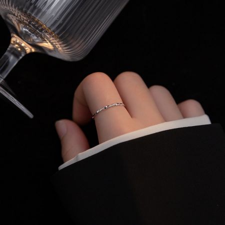 La mano de una mujer que lleva el anillo ajustable de plata 925 en estilo trenzado, mostrando su ajuste elegante.