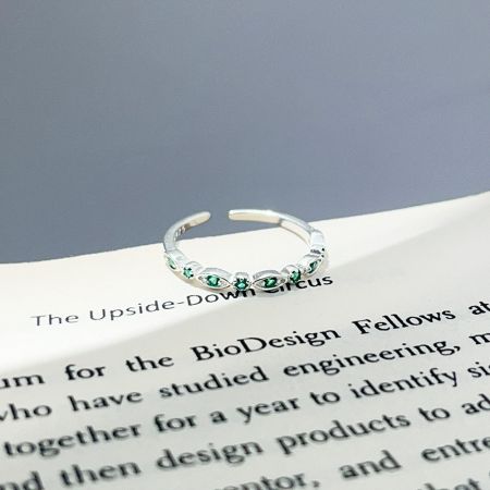 Detailed view of the 925 sterling silver open stacking ring with delicate green zircon stones.