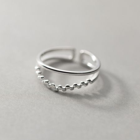 Vista detallada del diseño de cuentas en la mitad inferior del anillo de plata.