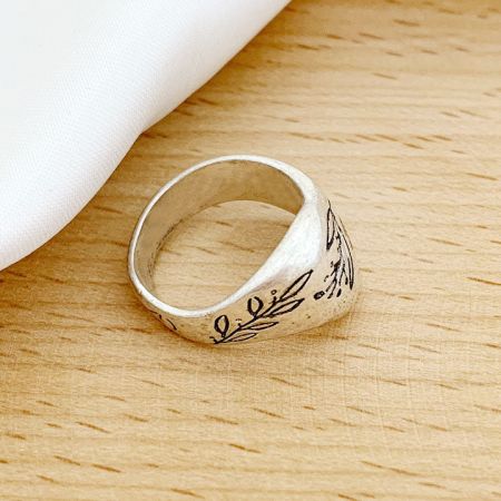 Product image of the silver brass ring highlighting its floral engravings.