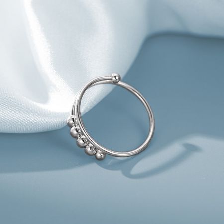 4つの装飾ビーズ付きのシルバースピニングリングの製品ショット。