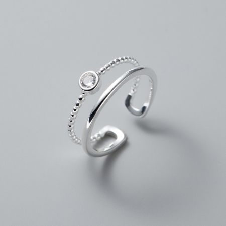 Nahaufnahme eines weiteren verstellbaren Rings aus dem Set, der das perlenbesetzte äußere Band und den zentralen Edelstein hervorhebt.