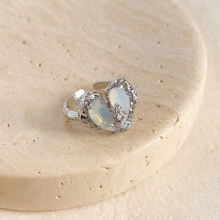 Primer plano de un anillo chapado en plata con dos piedras de ópalo en forma de lágrima.