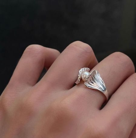Anello in Perla a Conchiglia in Argento Sterling 925 - Un primo piano dell'anello in perla a conchiglia in argento sterling 925 con un delicato design a forma di ala, indossato su un dito per mostrare la sua vestibilità regolabile.