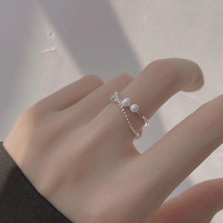Set di 5 Anelli Aperti a Perla Incrociata in Argento Sterling 925 con Zirconi - Un elegante disposizione del Set di Anelli Aperto a Perla Incrociata in Argento Sterling 925 con Zirconi, che mette in mostra i cinque design unici su uno sfondo neutro.