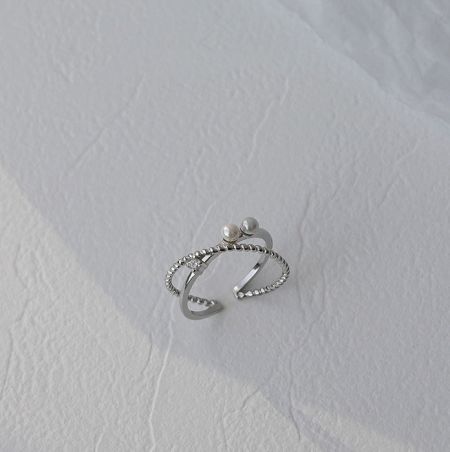 Bague en argent sterling 925 à double couche avec perle - Une photo de studio détaillée de la bague en argent sterling 925 à double couche avec perle, mettant en valeur son design complexe avec une perle d'eau douce centrale et des pierres en zircon cubique environnantes.