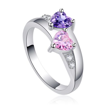 Profil latéral de la bague Double Cœur en CZ, mettant en valeur le sertissage complexe des pierres précieuses en forme de cœur violet et rose et les accents scintillants sur la bande.
