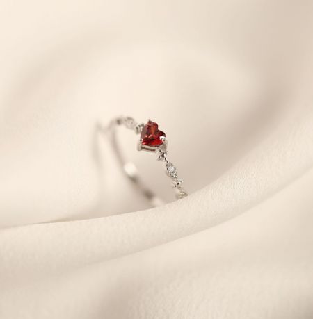 De 925 Sterling Zilveren Rode Hart Ring weergegeven in een strakke zilveren afwerking, met de peervormige rode edelsteen en delicate band.