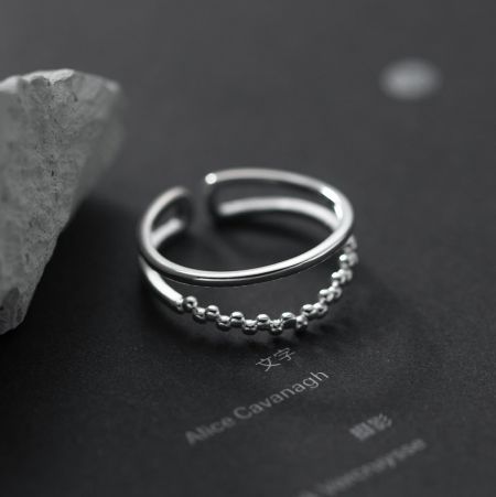 Otro ángulo del anillo de plata de doble capa con cuentas sobre un fondo blanco.