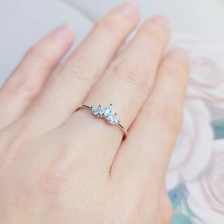 磨かれたバンドに3つの輝く洋ナシ型の宝石を特徴とする蓮の花びらのリングのスターリングシルバー版。