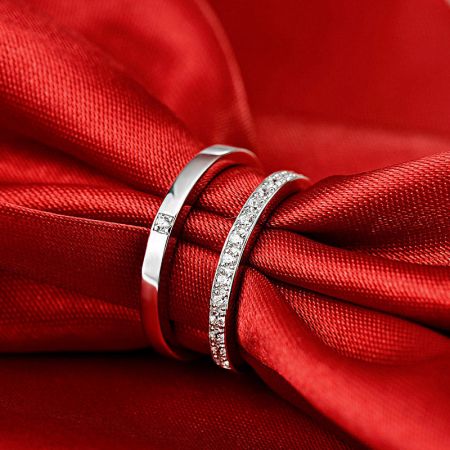 The matching 925 silver ring set displayed on a rich red fabric.