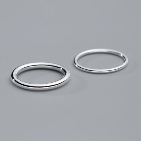 Zwei Stapelringe aus Sterlingsilber, die zusammen gezeigt werden, um zu veranschaulichen, wie sie für einen geschichteten Look kombiniert werden können.