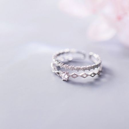 Dos anillos ajustables de plata S925 con piedras de circonio CZ brillantes sobre un fondo blanco.