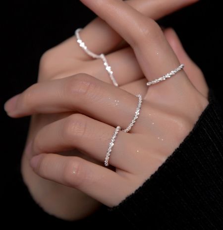 Anello a catena minimalista delicato in argento sterling 925. - Un primo piano di una mano che indossa l'anello a catena minimalista delicato in argento sterling 925, mostrando il suo design ondulato e delicato.