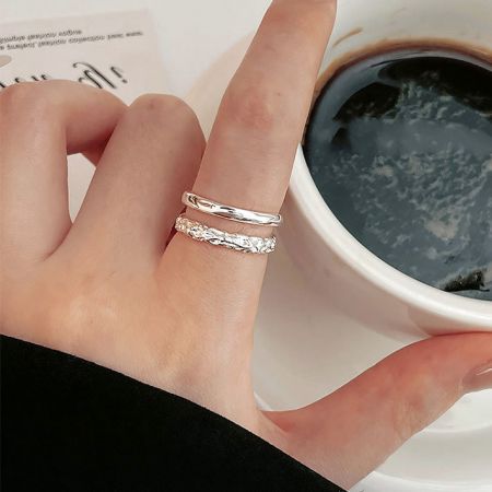 Een hand van een vrouw versierd met de set van vijf verstelbare sterling zilveren ringen, die laat zien hoe ze gestapeld en gestyled kunnen worden.