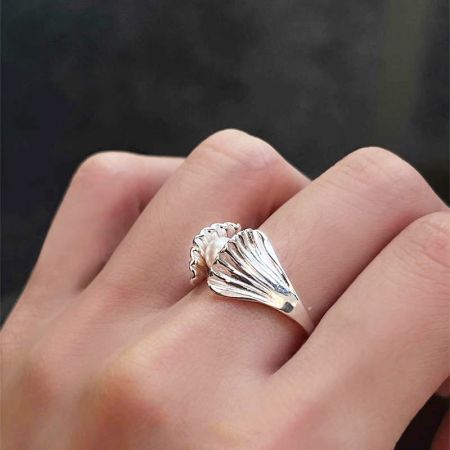 Un modelo que lleva un anillo de concha de plata esterlina 925 con una perla lustrosa, parte del conjunto de anillos ajustables.