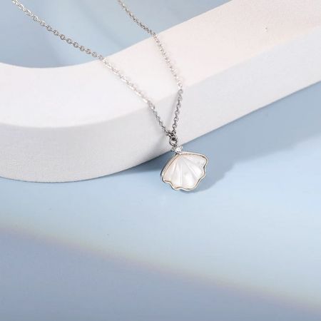 Professionally styled product shot of the silver sea shell necklace on a display stand.
