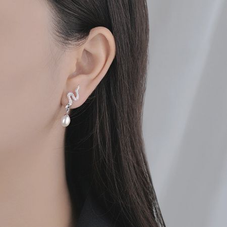 Model met de S925 sterling zilveren slang parel drop oorbel om schaal en stijl te tonen.