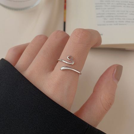 Primer plano del anillo de serpiente de plata esterlina 925 usado en un dedo, destacando su diseño abierto ajustable.