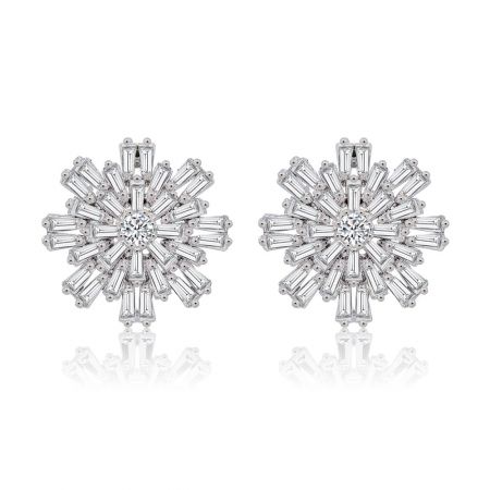 Orecchini dichiarativi Star Flake - Un paio di orecchini dichiarativi Star Flake in design a fiocco di neve, con un zirconia cubica rotonda centrale e pietre tagliate a baguette circostanti su uno sfondo bianco.