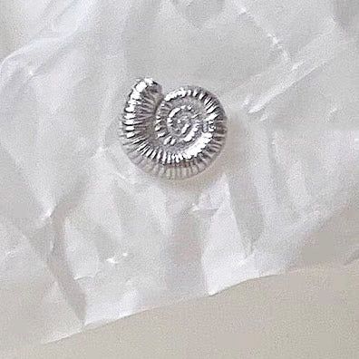 Another design from the asymmetrical sea shell earring set, showing intricate spiral details.