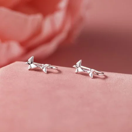 925 Zilveren Vlinder Oorbellen - Hypoallergene Kawaii Sieraden - Een set van 925 sterling zilveren oorbellen met vlinder-thema, weergegeven op een roze achtergrond, die hun delicate kawaii ontwerp toont. Hypoallergeen en ideaal voor groothandel.